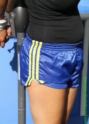 Женщина Сандра с кляпом во рту привязана к подставке для зонтов в одежде