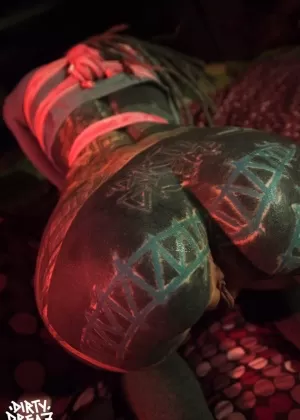 Сильно татуированная женщина связана розовой веревкой в очках