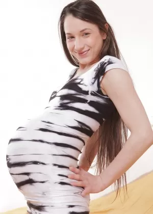 Беременная подросток демонстрирует свой живот в нижнем белье