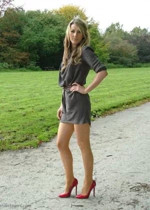 Горячая блондинка в туфлях на высоком каблуке выставляет напоказ свои сексуальные ножки и ступни на открытом воздухе