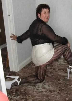 Зрелая леди кудрявая Кэрол показывает свои большие сиськи в колготках без промежности и на каблуках