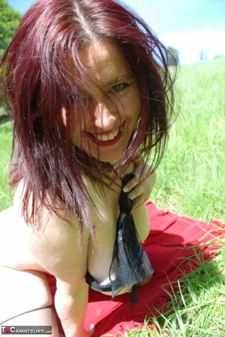 Британка средних лет Джуси Джейни демонстрирует свои большие сиськи и кустарник в поле