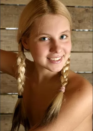 Молодая белокурая милашка с косичками позирует обнаженной, чтобы показать пухлые соски и крошечную попку