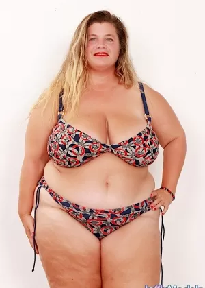 Толстая рыжеволосая Моник Похотливо сбрасывает красный бюстгальтер и трусики, чтобы раздеться догола