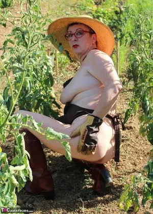 Зрелая женщина Мэри Сука обнажает свои сиськи и задницу, ухаживая за своим садом