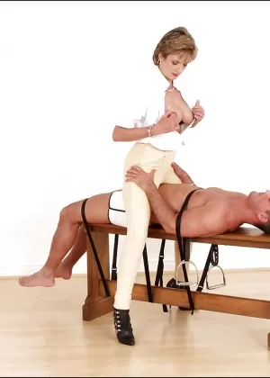 Пожилая госпожа Карли шлепает мужчину по голой заднице в короткой юбке и длинных сапогах