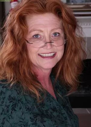 Молодая красотка в винтажной одежде любуется собой в зеркале раздеваясь