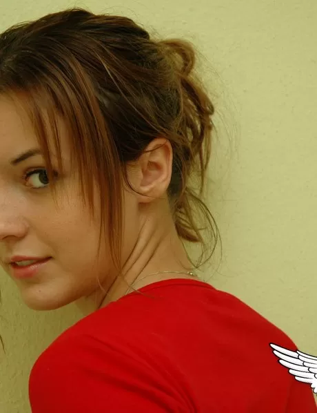 Симпатичная девушка-подросток моделирует не обнаженную натуру в красной рубашке и милых 7