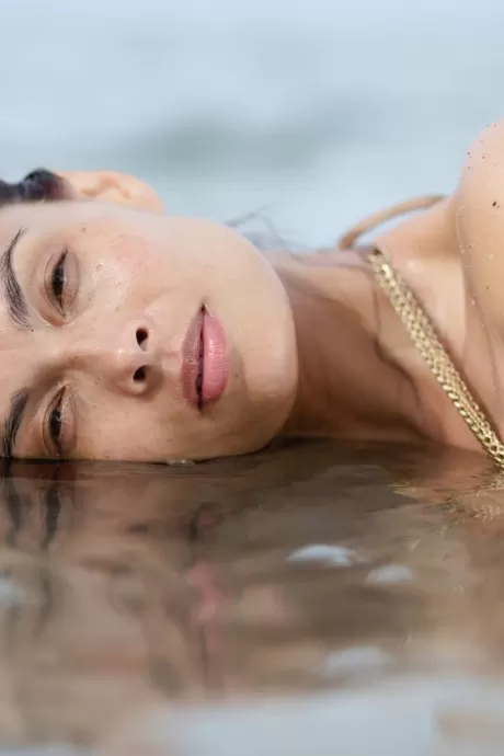 Азиатка Тера Патрик позирует в океане в золотом бикини