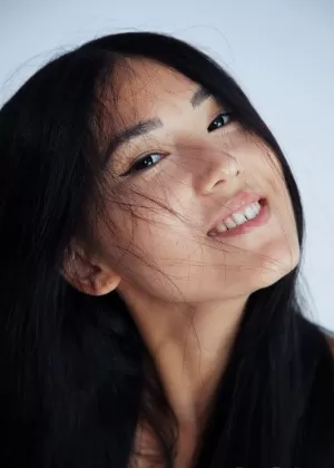 Молодая азиатка Кимико показывает свою безволосую киску, лежа голышом на кровати