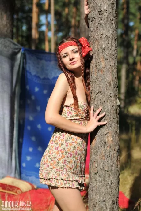 Симпатичная рыжеволосая Джулли раздевается догола в лесу, ее волосы заплетены  3