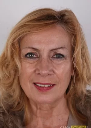 Пожилая женщина с приятным и твердым лицом раздевается до черных чулок