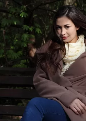 Девушка-подросток с рыжими волосами снимает джинсы, собираясь позировать обнаженной