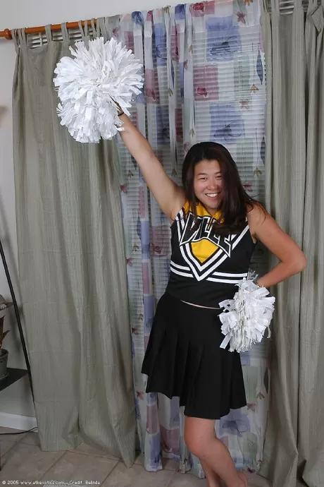 Asian amateur strips off cheerleader uniform before spreading pussy lips
