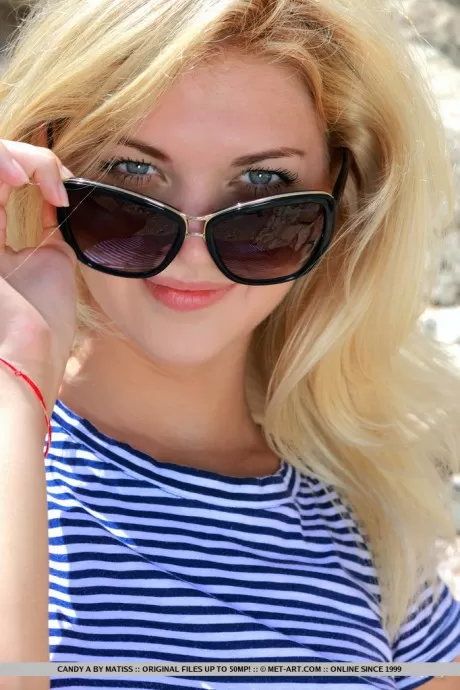 Молодая блондинка Кэнди А сбрасывает солнцезащитные очки и одеж 1