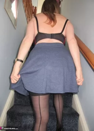 Зрелая женщина отодвигает трусики в сторону после того, как мелькает под юбкой на лестнице