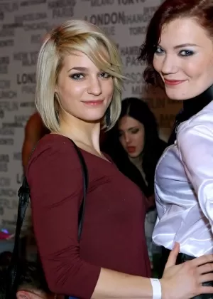 Одинокая девушка Али Бордо приседает для этого на мощеной дорожке в кожаных сапогах