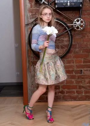 Худенькая юная фея света снимает свою одежду и очки, чтобы позировать обнаженной