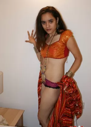 Горячая индианка с упругой грудью показывает свою голую и лысую пизду в чулках