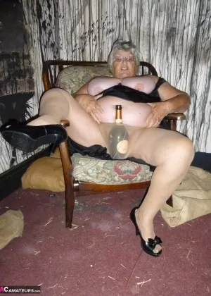 Зрелая бабуля Савана в красном нижнем белье смеется, когда она сексуально позирует на кровати