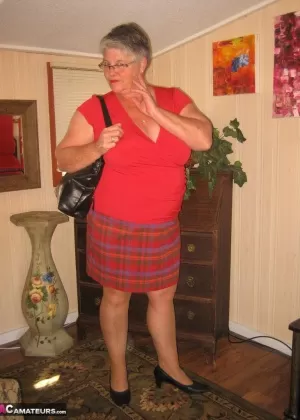 30-летняя женщина с рыжими волосами снимает белое нижнее белье для куколки, чтобы позировать обнаженной