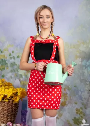 Симпатичная молоденькая Полина держит свои заплетенные косички после того, как раздевается догола