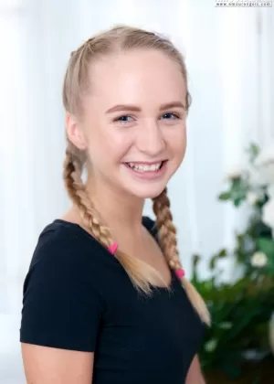 Молодо выглядящая девушка обнажает свое загорелое тело в белых школьных носках