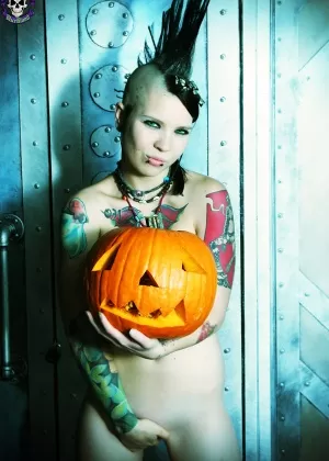 Альтернативная девушка Тара Токсик вырезает тыкву в высоких ботинках и ботинках