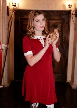 Милая девушка задирает свое элегантное платье, чтобы обнажить свои стринги в сексуальных чулочно-носочных изделиях