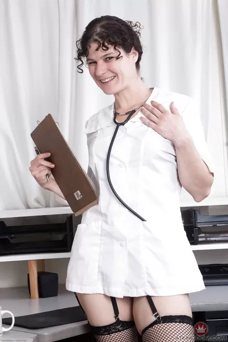 Зрелая брюнетка Саншайн сбрасывает докторскую одежду, прежде чем обнажить волосатую пизду