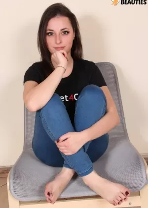 Брюнетка соло девушка Илария показывает свои босые ноги во время моделирования не обнаженной в джинсах