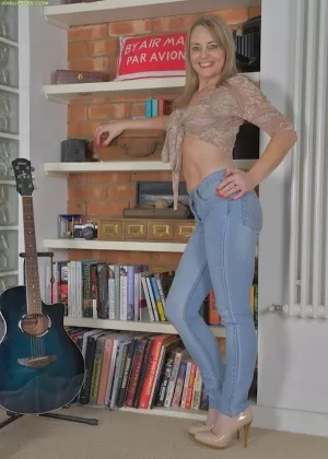 Похотливая зрелая красотка приспускает свои обтягивающие джинсы и дразнит свою киску