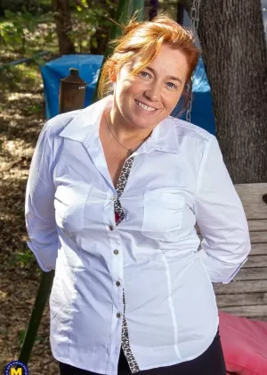 Толстая зрелая рыжая мастурбирует на скамейке-качелях на заднем дворе