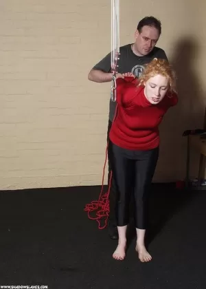 Clothed female with curly red hair is gagged before tit torture begins